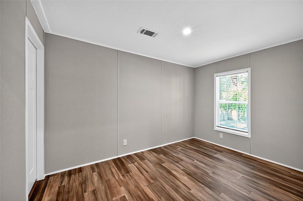 134 Weerts Road San Mateo, FL 32187 - Photo 18 of 32 an empty room with wooden floor and windows