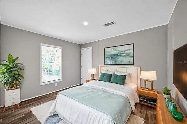 a bedroom with a bed and wooden floor