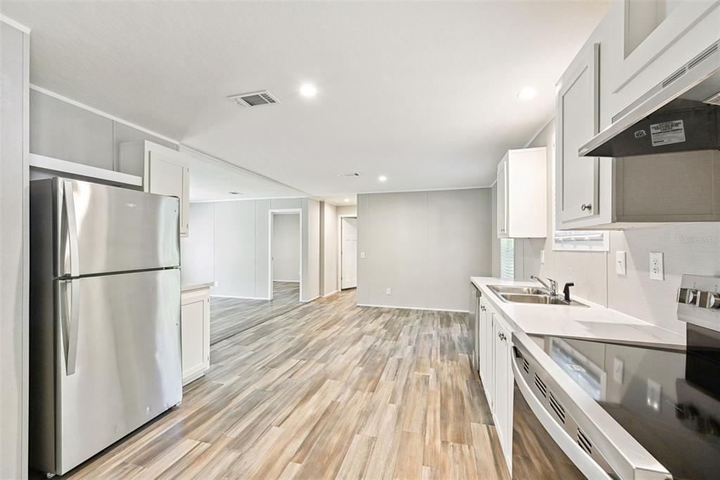 134 Weerts Road San Mateo, FL 32187 - Photo 3 of 32 a kitchen with a sink a refrigerator and cabinets