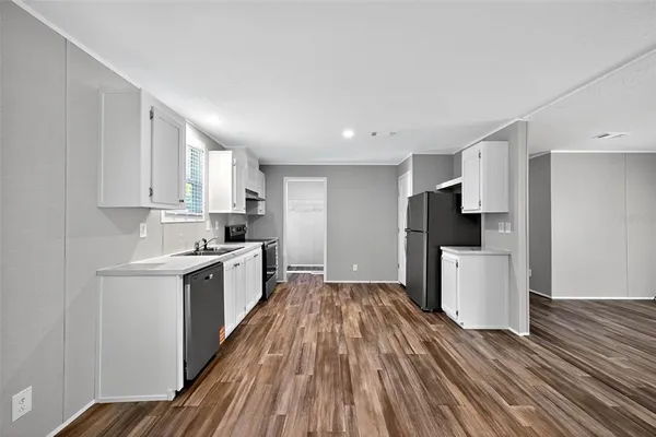 a kitchen with a refrigerator and white cabinets