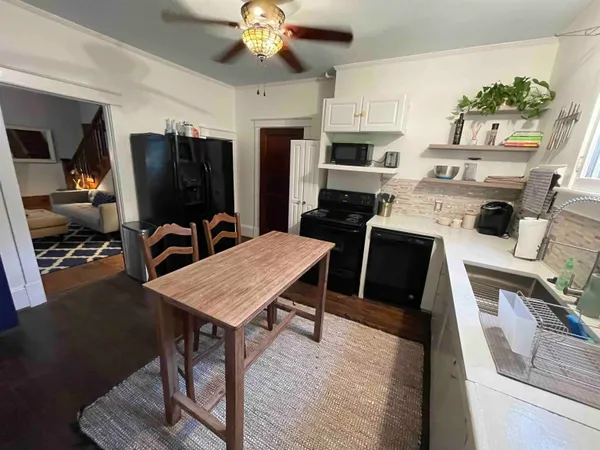 a view of a dining room with furniture a rug and wooden floor