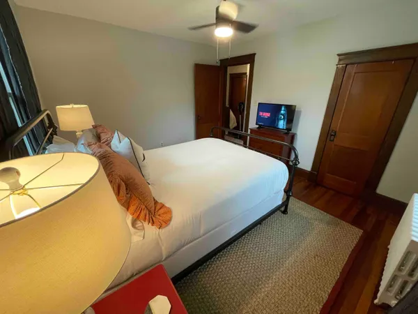 a bedroom with a bed dresser and a large mirror