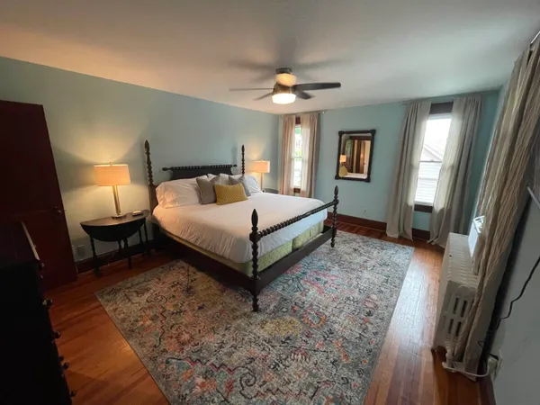 a spacious bedroom with a bed and a dresser