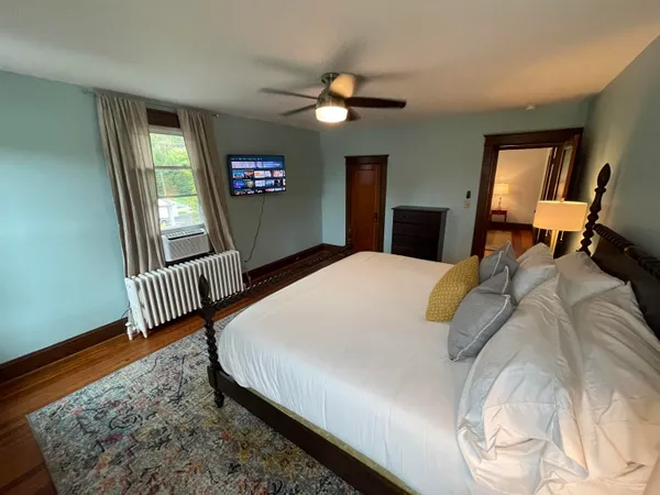 a bedroom with a bed dresser and a window