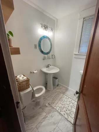 a bathroom with a sink toilet and mirror