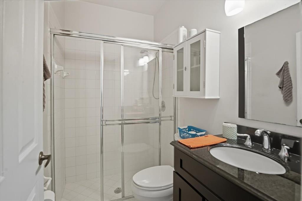 7631 Northwest 87th Terrace Tamarac, FL 33321 - Photo 12 of 23 a bathroom with a granite countertop sink toilet a mirror a vanity and shower