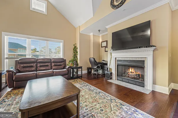 a living room with furniture a flat screen tv and a fireplace