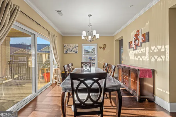 a view of a dining room with furniture wooden floor and chandelier