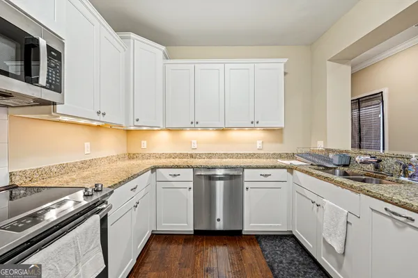 a kitchen with a sink stove top oven and cabinets