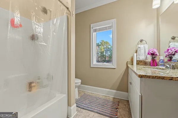 a bathroom with a granite countertop sink a bathtub and shower