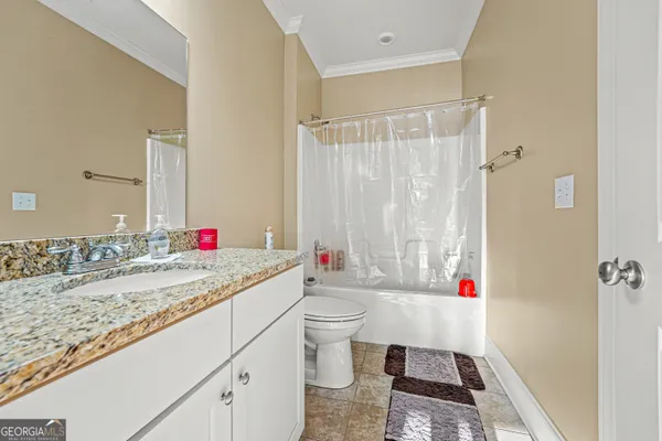 a bathroom with a granite countertop sink mirror vanity and toilet