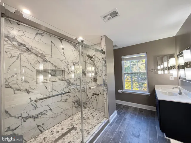 a bathroom with a bathtub sink shower and mirror