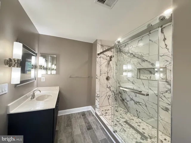 a bathroom with a wooden floor and a shower