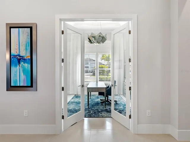 a living room with lots of white furniture and view of kitchen