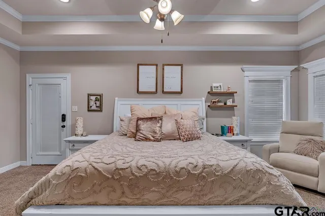 a bedroom with a large bed couch and windows