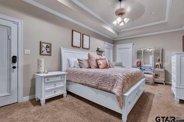 a bedroom with a large bed and ceiling fan