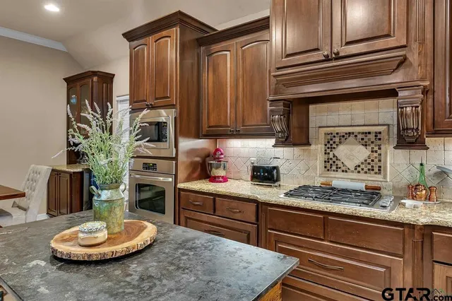 a kitchen with stainless steel appliances granite countertop a sink stove and cabinets
