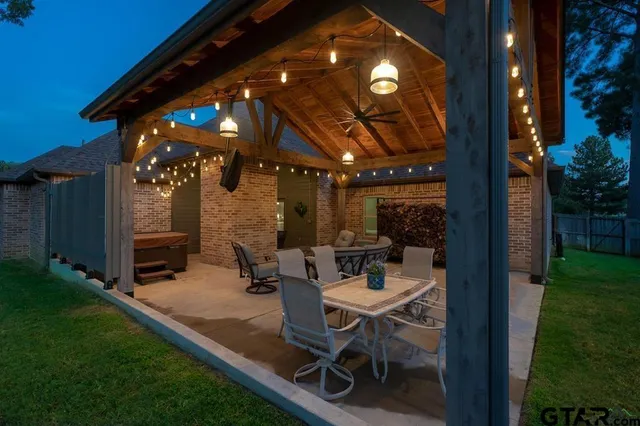 a view of a patio with table and chairs with plants and wooden fence