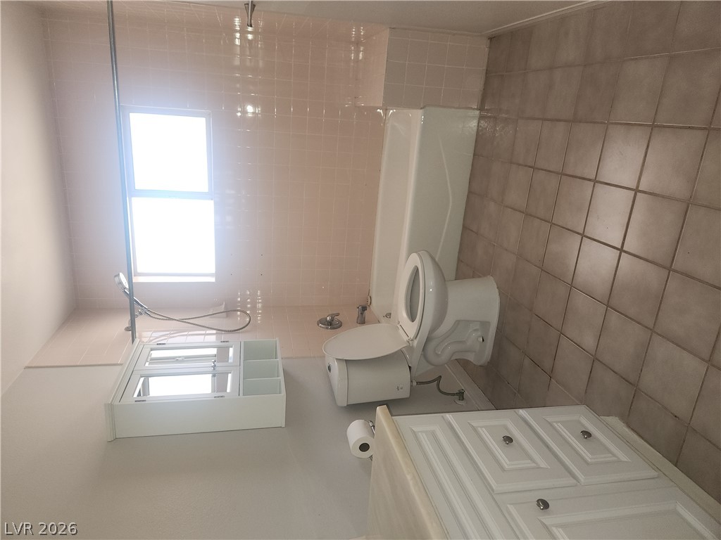 564 Ridgeway Road Henderson, NV 89015 - Photo 13 of 22 A well-lit bathroom with tile flooring, a functional bathtub, and a vanity for everyday convenience.