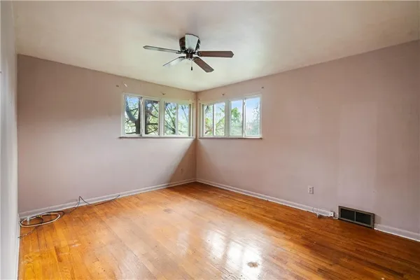 wooden floor in an empty room with a window