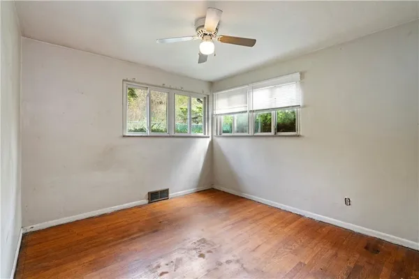 a view of a room with wooden floor and fan