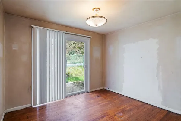 a view of a room with wooden floor and white walls