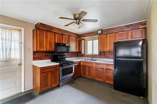 a kitchen with stainless steel appliances granite countertop a refrigerator a stove a sink and a microwave