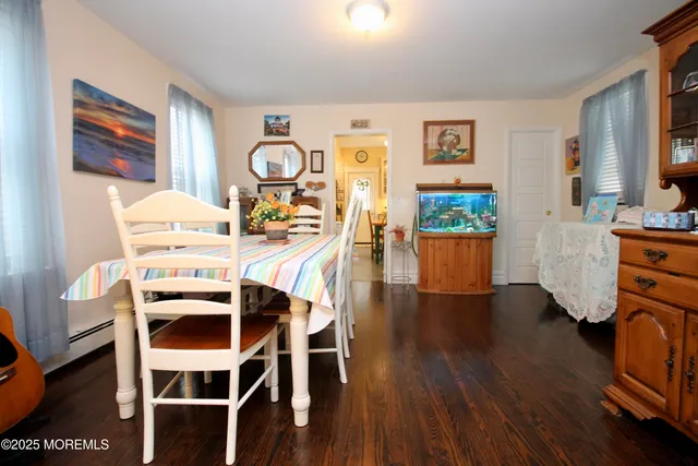 a dining room with wooden floor a chandelier a glass table and chairs