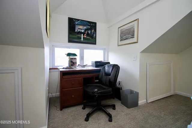 a view of a workspace with furniture and a window