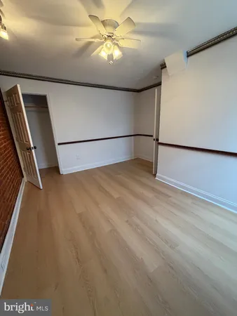 a view of a refrigerator in kitchen and utility room with wooden floor