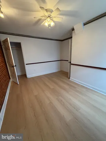 a view of a refrigerator in kitchen and utility room with wooden floor