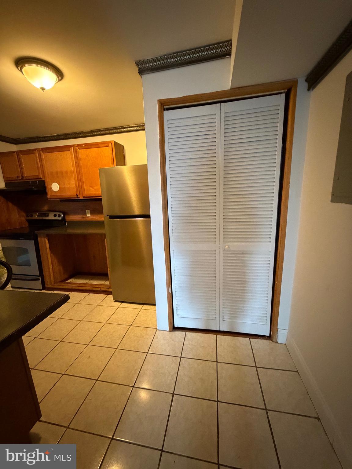 1841 West Lexington Street, Unit 3 Baltimore, MD 21223 - Photo 13 of 14 a view of a refrigerator in kitchen and utility room with wooden floor