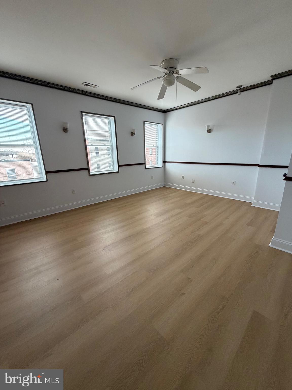 1841 West Lexington Street, Unit 3 Baltimore, MD 21223 - Photo 3 of 14 an empty room with wooden floor and windows