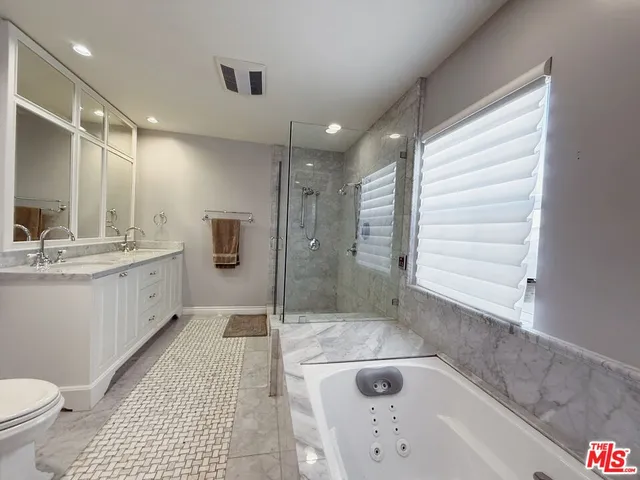 a bathroom with a tub a sink and a large mirror