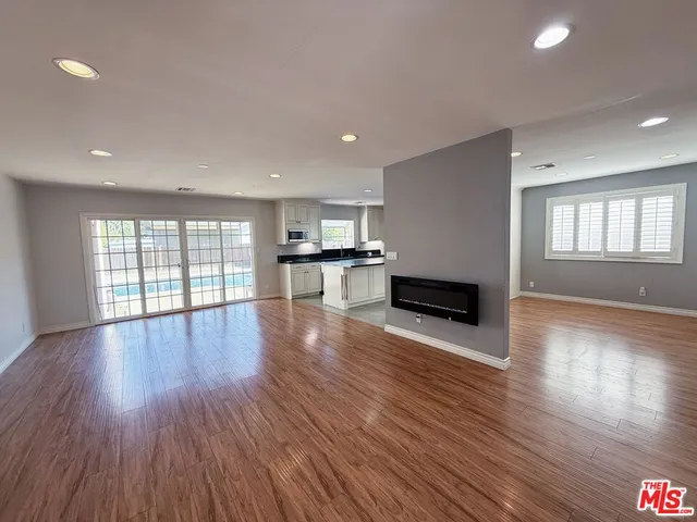 a view of a big room with wooden floor and windows