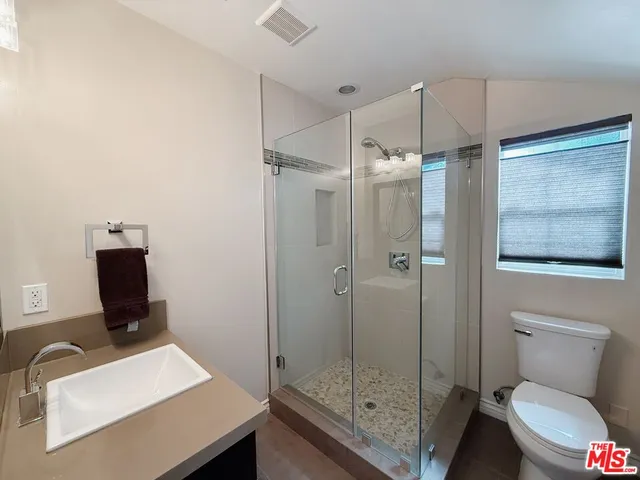 a bathroom with a toilet a sink and shower