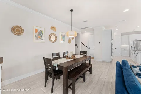 a kitchen with stainless steel appliances kitchen island granite countertop a table chairs and a refrigerator