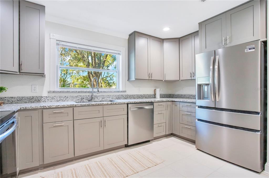 619 Marphil Loop Brandon, FL 33511 - Photo 15 of 36 a kitchen with stainless steel appliances granite countertop a refrigerator sink and cabinets