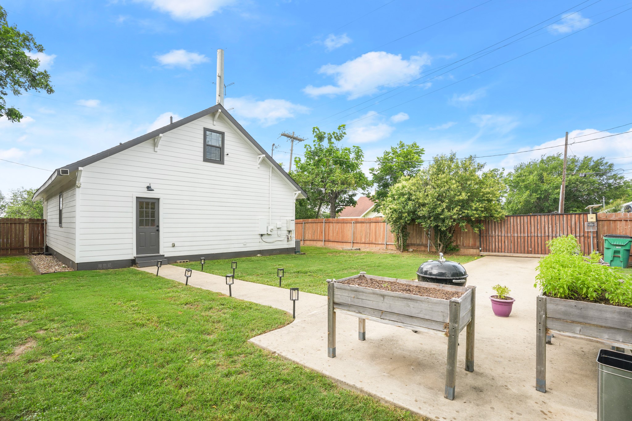 301 Old Thorndale Road Taylor, TX 76574 - Photo 27 of 29 A quaint backyard with a wooden fence and raised garden beds, perfect for outdoor living.