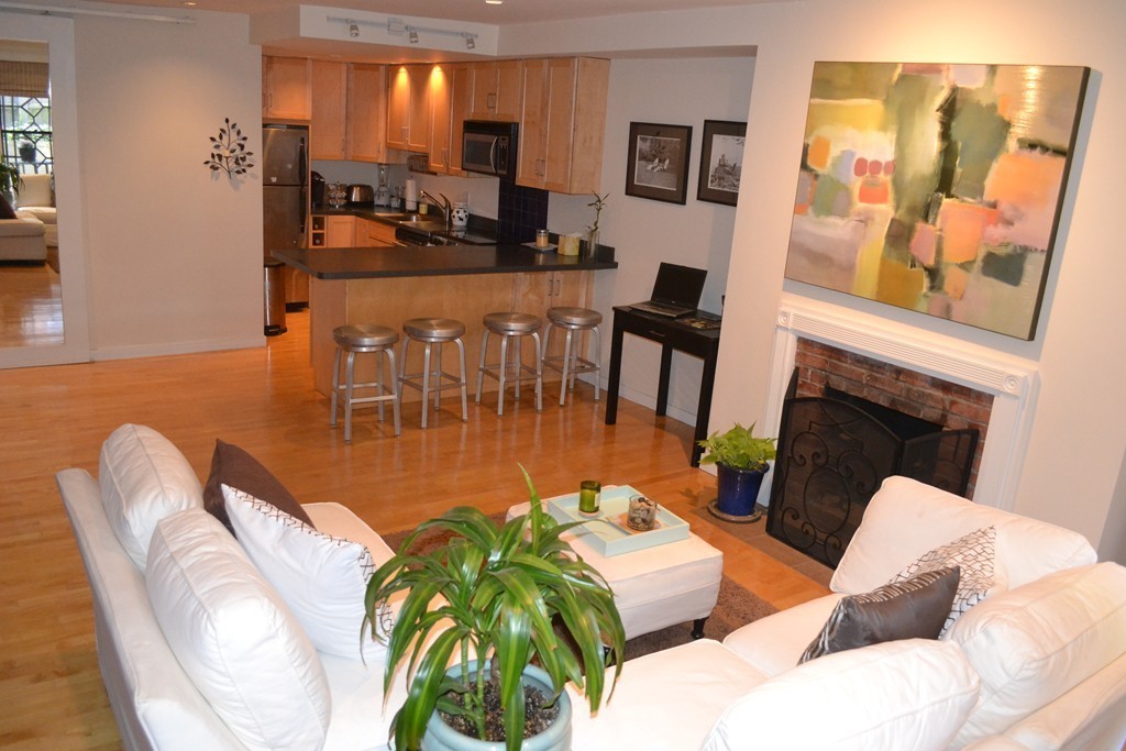 315-317 Beacon Street, Unit 1 Boston, MA 02116 - Photo 2 of 11 a living room with furniture a fireplace and a flat screen tv