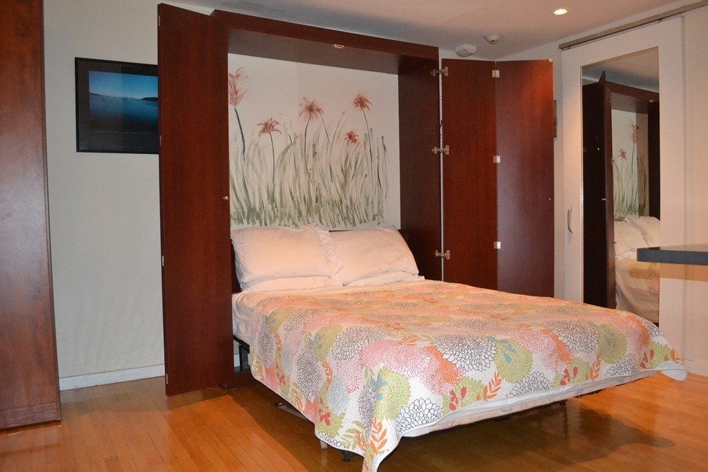 315-317 Beacon Street, Unit 1 Boston, MA 02116 - Photo 6 of 11 a bedroom with a large bed and a chandelier