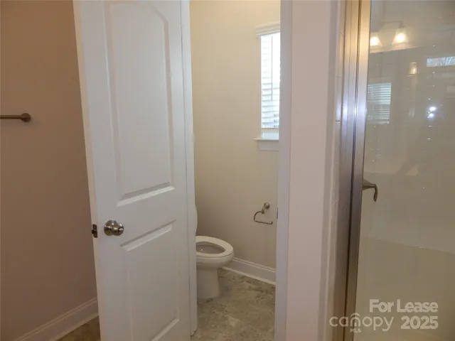 a bathroom with a granite countertop toilet a sink and a mirror