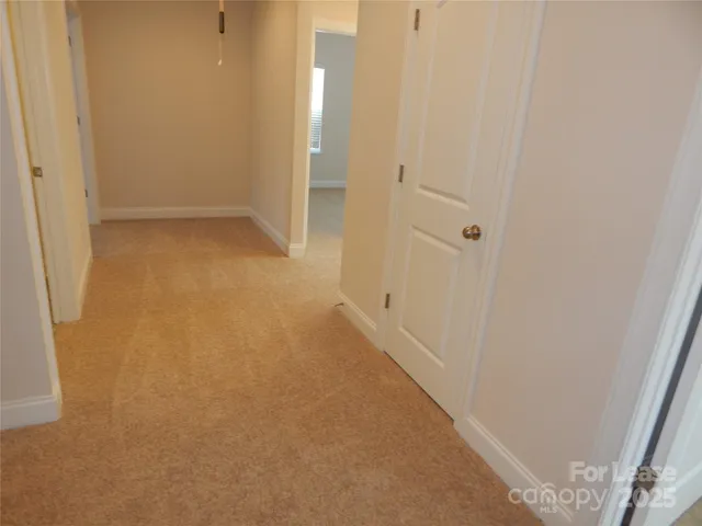 a view of hallway with a bathroom