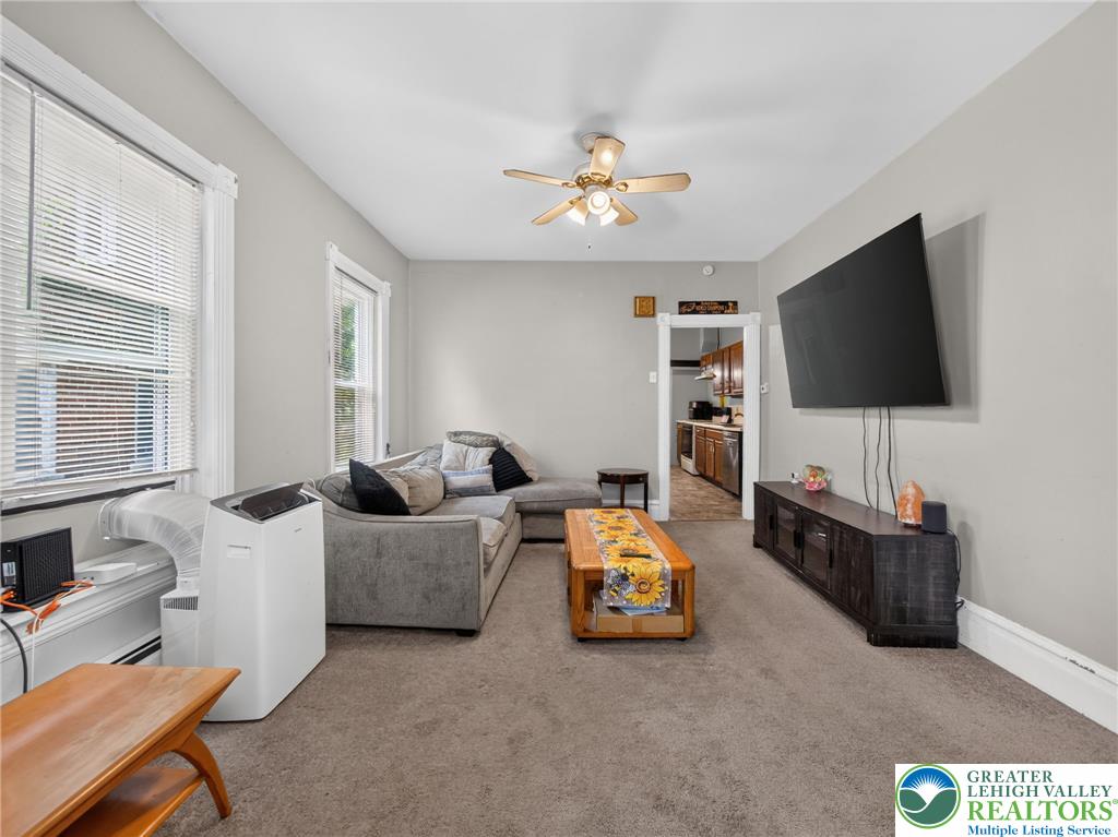 425 Ridge Street Emmaus, PA 18049 - Photo 8 of 27 A comfortable living space featuring soft carpeting and a well-placed ceiling fan for air circulation.