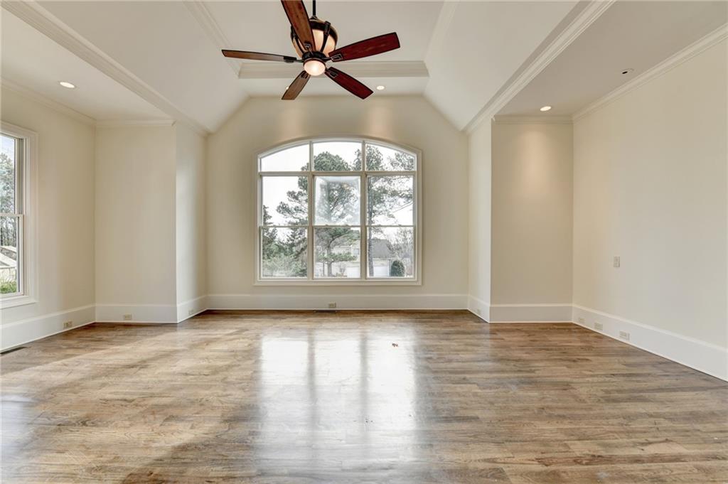 4045 Ridge Road Buford, GA 30519 - Photo 36 of 97 an empty room with wooden floor chandelier fan and windows