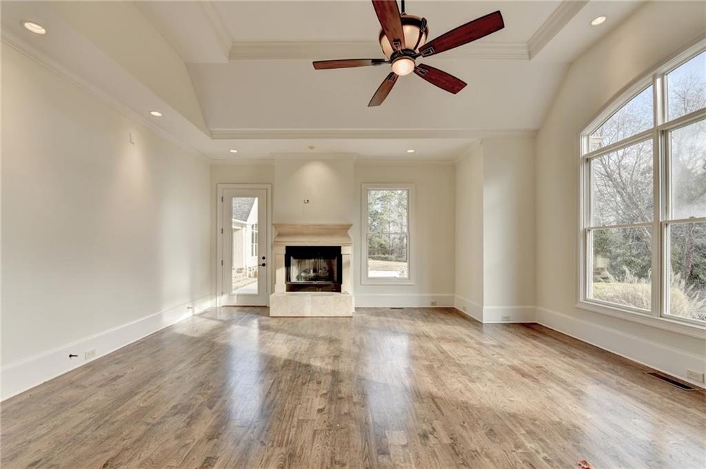 4045 Ridge Road Buford, GA 30519 - Photo 38 of 97 an empty room with windows fireplace and a ceiling fan