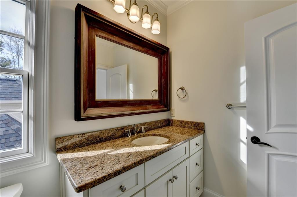 4045 Ridge Road Buford, GA 30519 - Photo 56 of 97 a bathroom with a granite countertop sink a mirror and a vanity