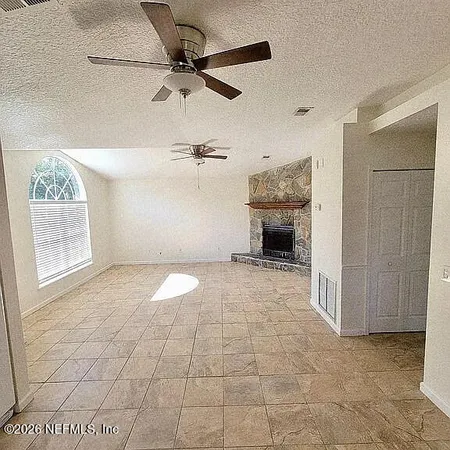 a view of a livingroom with a ceiling fan and window