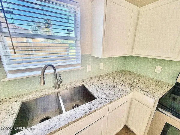 a kitchen with granite countertop a sink and a wooden cabinets