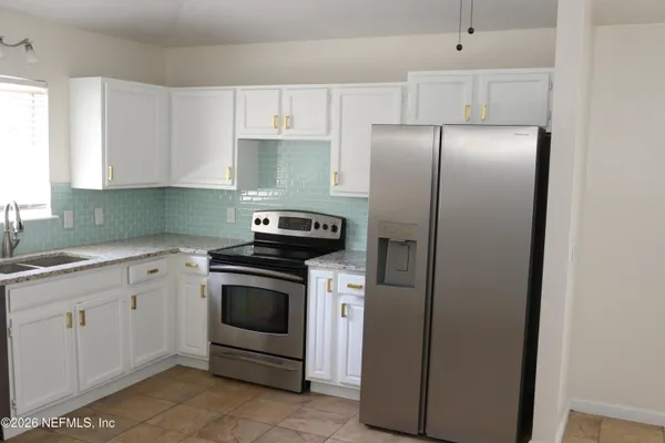 a kitchen with cabinets and stainless steel appliances